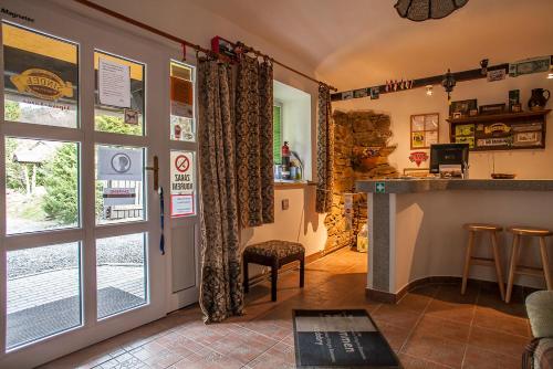 a room with a bar and a kitchen with a window at Penzion SATEK in Lipova Lazne