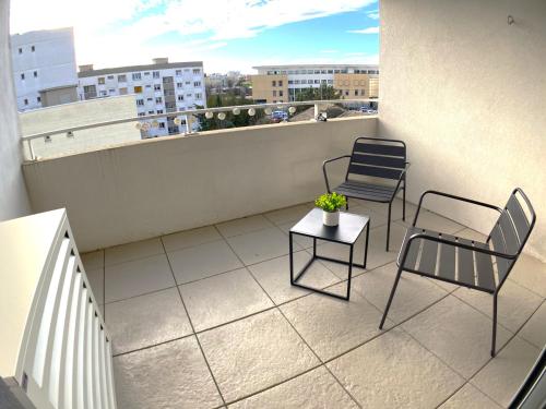 deux chaises et une table sur un balcon avec vue dans l'établissement T2 Coeur de Ville Montpellier Proche Port Marianne, à Montpellier