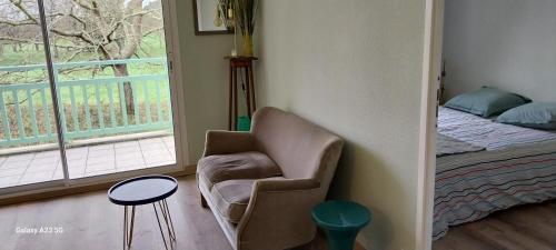 Cette chambre comprend une chaise, un lit et une fenêtre. dans l'établissement joli appartement bord de mer, à Pornic