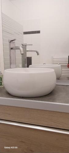 La salle de bains est pourvue de 2 lavabos et de 2 robinets installés sur un comptoir. dans l'établissement joli appartement bord de mer, à Pornic