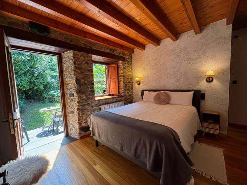 Un dormitorio con una cama y una ventana grande. en Casa Rural O Vilar, en Mera de arriba