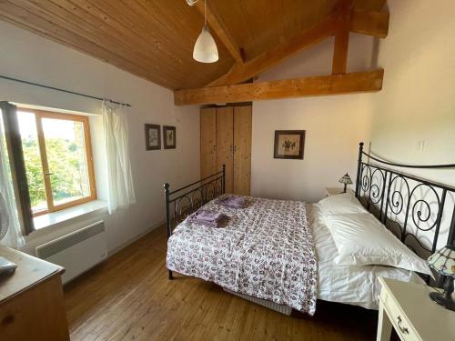 une chambre avec un lit et une fenêtre dans l'établissement 23, Grande Rue, Patreville, Val D'Auge, Charente, à Saint-Médard