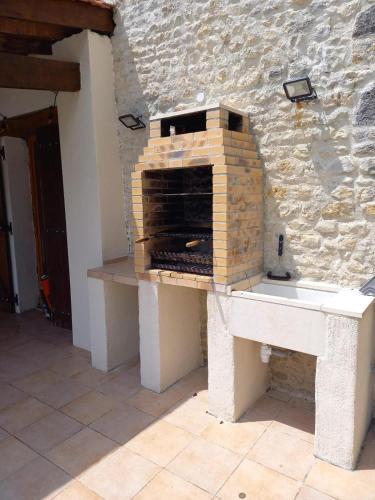 Un four en briques est installé au-dessus d'un mur en pierre. dans l'établissement 23, Grande Rue, Patreville, Val D'Auge, Charente, à Saint-Médard