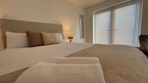 a bedroom with a large white bed with a window at Little Luxe shared house in Bristol