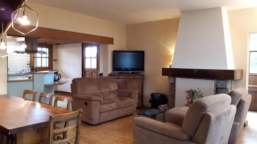 - un salon avec une cheminée, une table et des chaises dans l'établissement Maison Croas Zellour, à Ploubazlanec