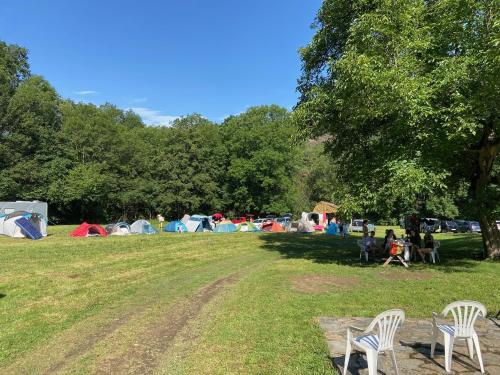 a group of tents in a field with two chairs at La Bastide d'Albignac in Le Dourn