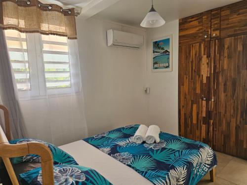 a bedroom with a bed with towels on it at Appartement Bleu Corail avec Jacuzzi in Les Trois-Îlets