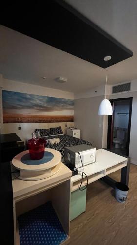 a room with a bed and a table with a bowl on it at FLAT NO CORAÇÃO De ALPHAVILLE in Barueri