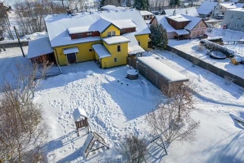 an aerial view of a snow covered neighborhood with a yellow house at Apartmány U Šťastných in Cerny Dul