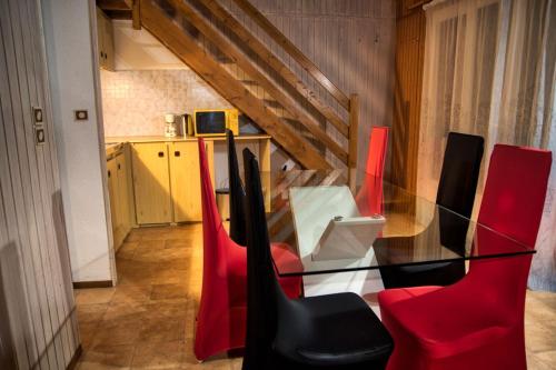 a glass table and red chairs in a room at La Bastide d'Albignac in Le Dourn