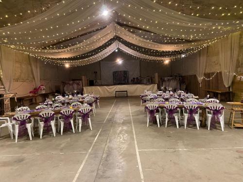a banquet hall with tables and chairs and lights at La Bastide d'Albignac in Le Dourn