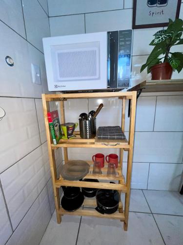 a microwave on top of a shelf in a kitchen at Jacarandá I in Florianópolis