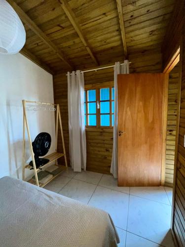 a bedroom with a bed and a wooden door at Jacarandá I in Florianópolis