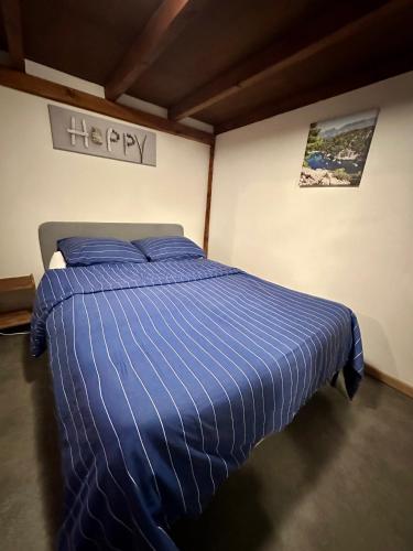 - un lit avec une couette bleue dans l'établissement Joli Appartement aux Chartreux - Calme & lumineux, à Marseille