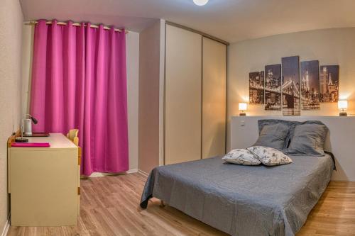 a bedroom with a bed with a pink curtain at La Bastide d'Albignac in Le Dourn