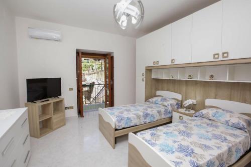 una camera da letto con due letti e una TV a schermo piatto di La Dea del mare a Maiori