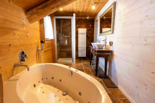 a large tub in a bathroom with a sink at Chalet Dent d'Oche - A Dream Family Stay in Morgins