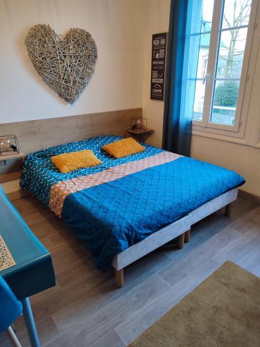 - une chambre avec un lit et un cœur sur le mur dans l'établissement Studio 10, très bien placé, parking wifi gratuit, à Bagnoles-de-l'Orne