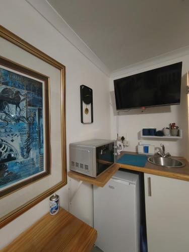 a small kitchen with a microwave and a sink at La Damon 1 in Paarl