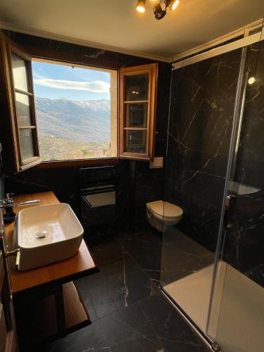 une salle de bain avec une douche et un lavabo et une fenêtre dans l'établissement Villa avec vue panoramique sur les montagnes, à Corscia