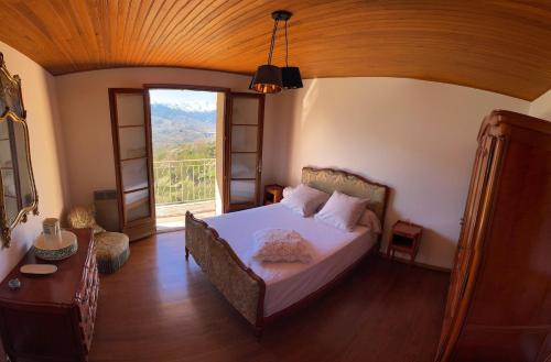 une chambre avec un lit et une grande fenêtre dans l'établissement Villa avec vue panoramique sur les montagnes, à Corscia