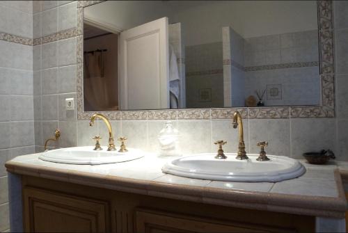 a bathroom with two sinks and a large mirror at Le Balcon De Roxane in Malaucène