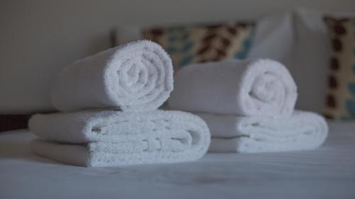 a pile of towels sitting on top of a bed at Vizion Suites Milton Keynes - Free WiFi, Netflix Secure, Parking, Fully Furnished & Equipped Apartments in Milton Keynes