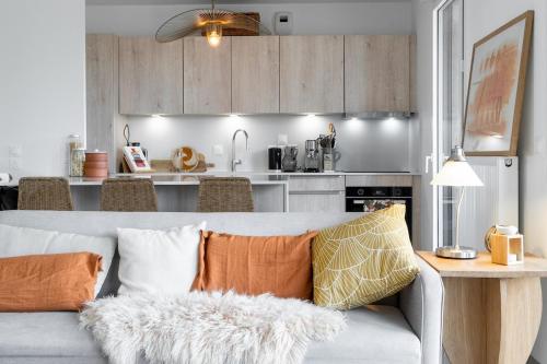 un salon avec un canapé et une cuisine dans l'établissement Spacious bright contemporary apartment, à Bordeaux