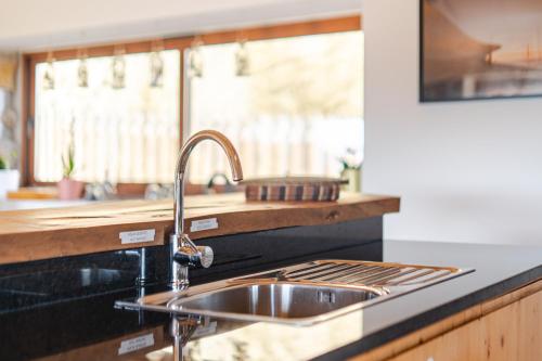 a kitchen counter with a sink and a window at CASA DO SOL , Turismo Rural in Celorico de Basto