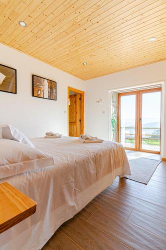 a bedroom with a large bed with a wooden ceiling at CASA DO SOL , Turismo Rural in Celorico de Basto