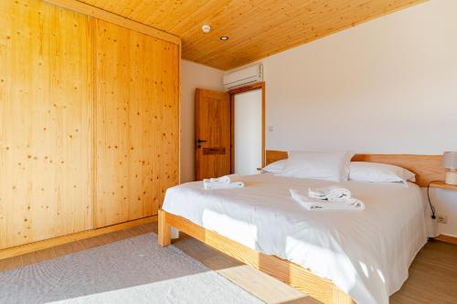 a bedroom with a large bed with wooden walls at CASA DO SOL , Turismo Rural in Celorico de Basto