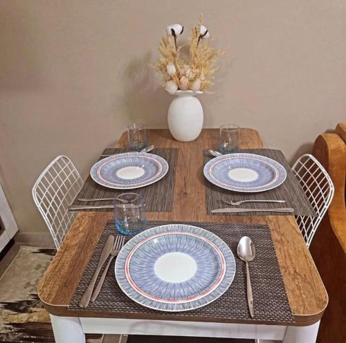 a wooden table with blue and white plates on it at Blue View Apartment in Himare