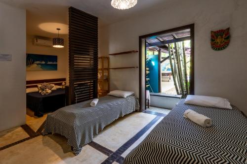 two beds sitting in a room with a window at House da Lui in Ubatuba