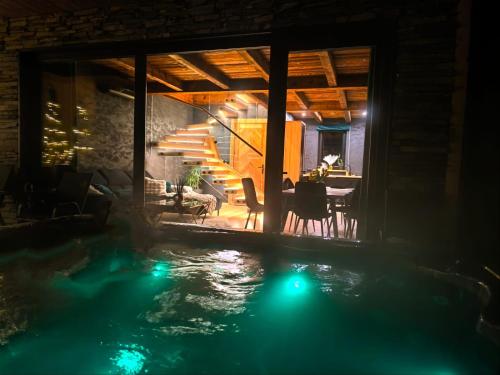 a house with a swimming pool at night at Domki TATRA HOMES z jacuzzi in Kościelisko