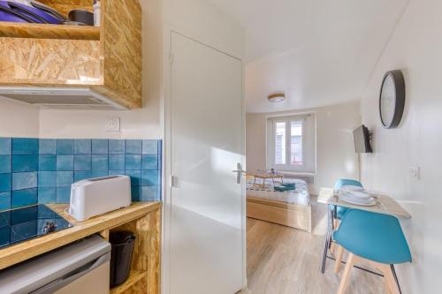une petite cuisine avec une table et une chaise bleue dans l'établissement Le Nid Azur Cosy Studio Proche De Paris, à Le Pré-Saint-Gervais