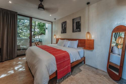 a bedroom with a large bed with a red blanket at MUR MURA Boutique Guesthouse in Campeche