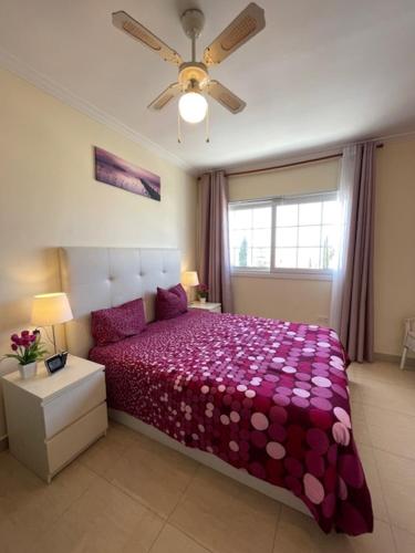 a bedroom with a purple bed and a ceiling fan at Carlos in Callao Salvaje