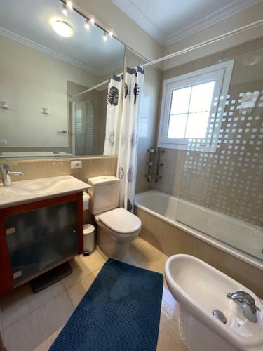 a bathroom with a toilet and a sink and a tub at Carlos in Callao Salvaje