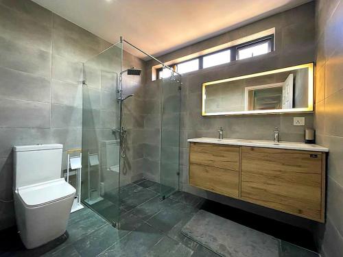 a bathroom with a shower and a toilet and a sink at Spacious and Modern beach apartment in Flic-en-Flac