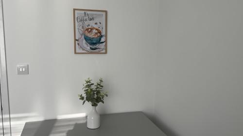 un vase assis sur une table avec une photo sur le mur dans l'établissement The cozy, à Bristol