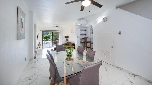 a dining room with a glass table and chairs at Casa con vista a la Marina, A UNOS PASOS DE LA PLAYA in Puerto Aventuras