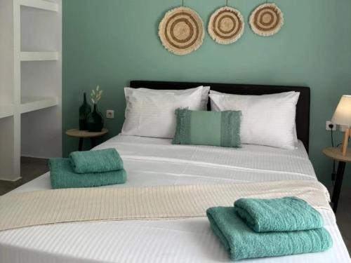 - un lit avec des oreillers verts et blancs dans l'établissement Villa kontes kefalonia, à Kardhakáta