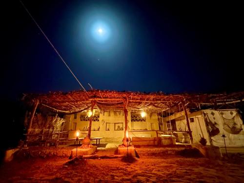a building at night with the moon in the sky at Dar Kafoura Siwa in Siwa