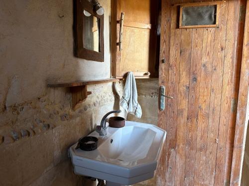 a bathroom with a sink and a wooden door at Dar Kafoura Siwa in Siwa