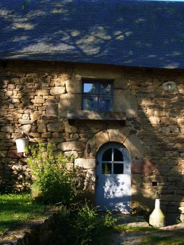 een stenen huis met een blauwe deur en een raam bij La Grange de Coatélan in Plougonven