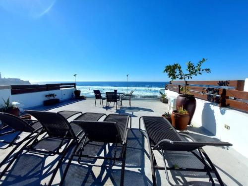 a group of chairs sitting on a patio overlooking the ocean at Beachfront Boutique Villa Cazadores in Rosarito