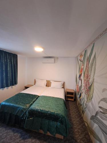 a bedroom with a bed and a painting on the wall at Casa Sofia in Târgu Jiu