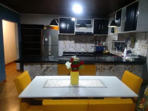 eine Küche mit einem Tisch mit einer Vase mit Blumen darauf in der Unterkunft casa in Rio Verde