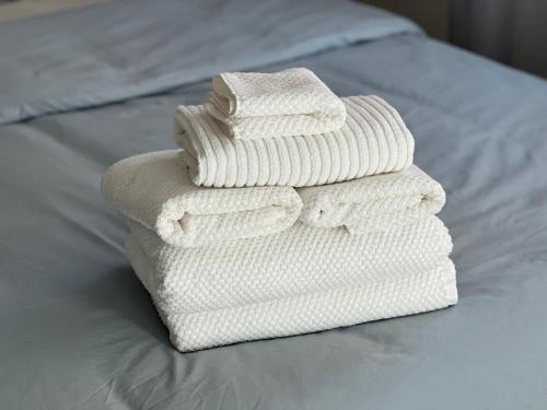 three towels stacked on top of a bed at Central Menton Beach Retreat in Menton