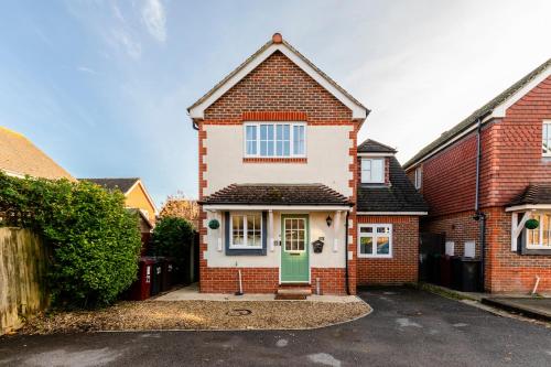 a red brick house with a green door at Chichester retreat house with free parking in Chichester